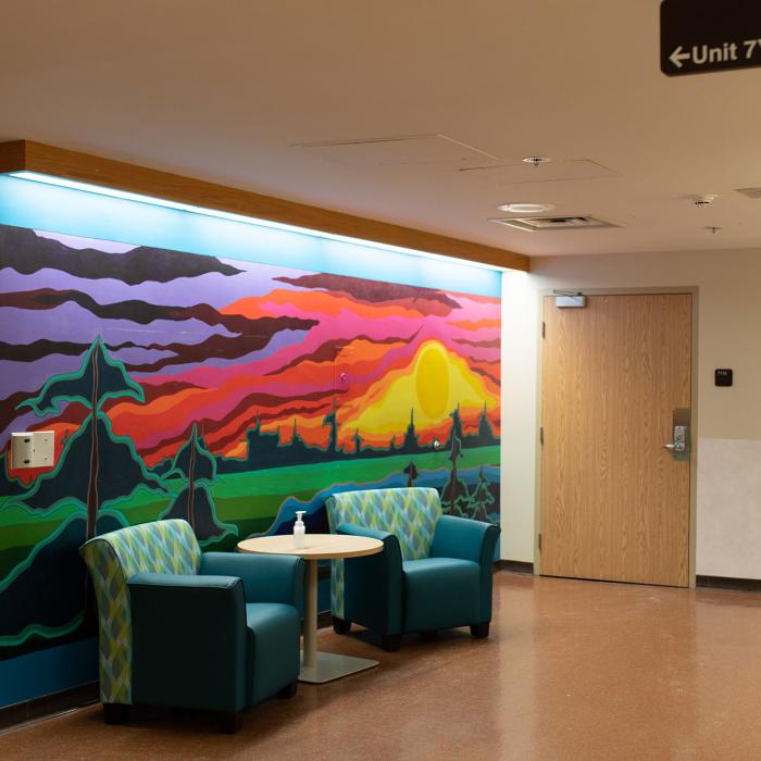 Sitting area with large mural of sunset