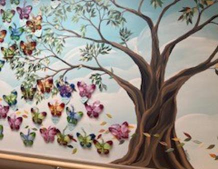 Painted mural of a tree and a kaleidoscope of butterflies