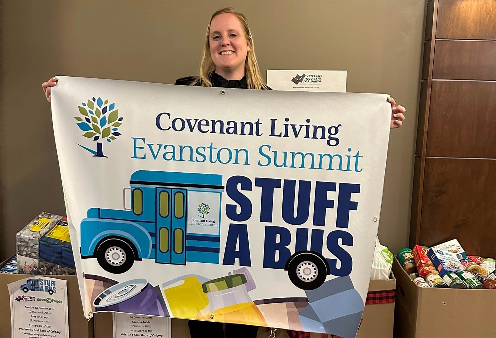 A woman holds up a sign for Evanston Summit's Stuff A Bus food drive