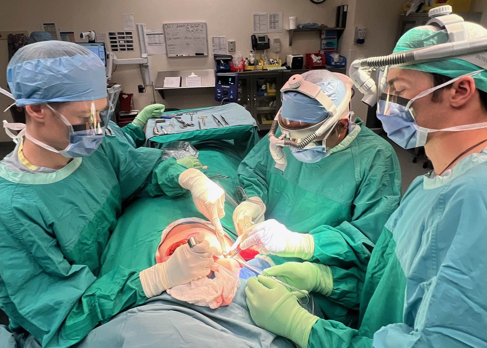 Three surgeons operate on a breast cancer patient