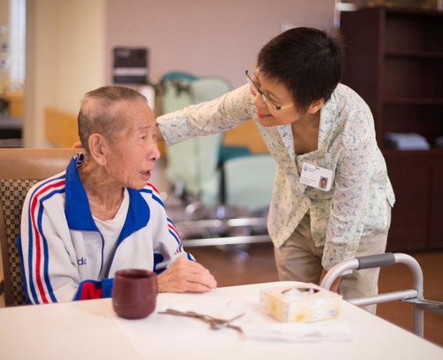 A Covenant Health staff member has a conversation with a continuing care resident.