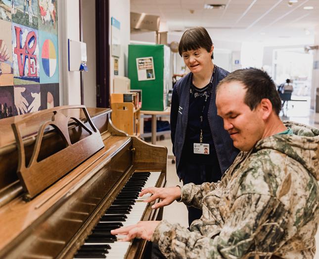 A volunteer plays the piano in the Misericordia hospital lobby