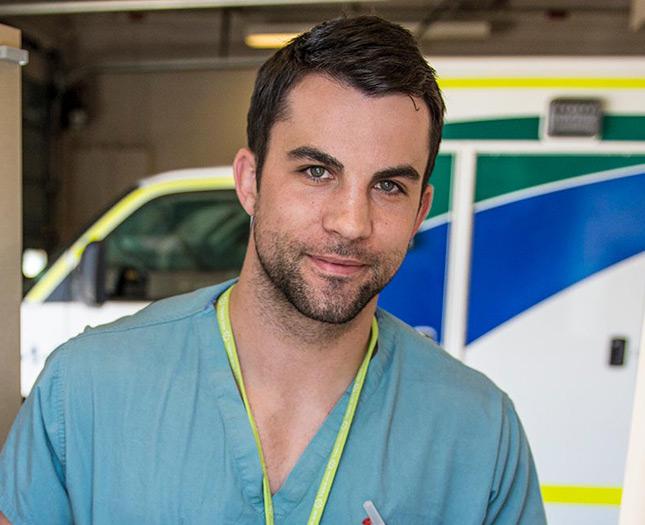 Student jobs A smiling young man wearing scrubs in front of an ambulance