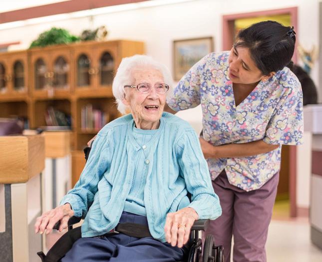 A staff member interacts with a resident in a wheelchair