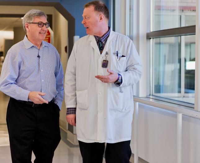 Ethics and Discernment Centre A physician and patient walk and talk down a hospital hallway.