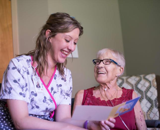 A staff member reads to a resident.