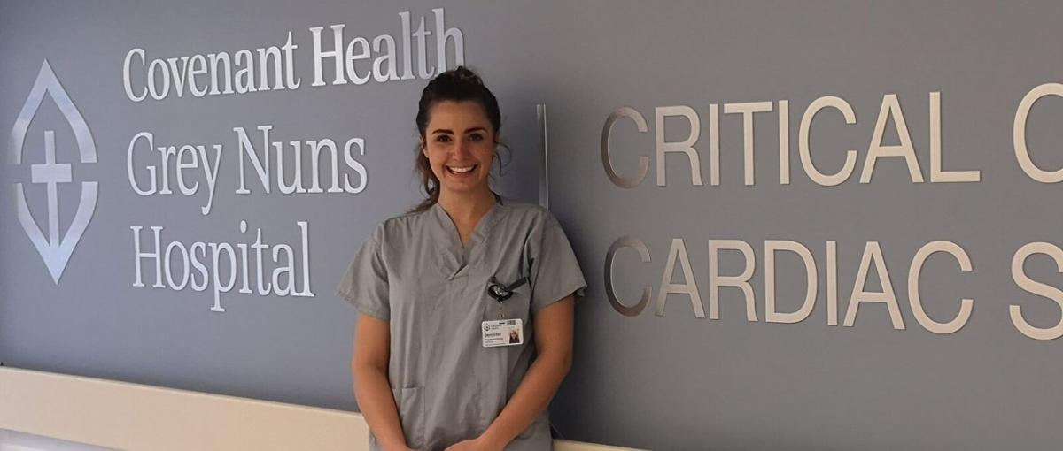 Registered nurse Jennifer Hamilton in front of signage for the Grey Nuns Hospital's Critical Care and Cardiac Sciences unit