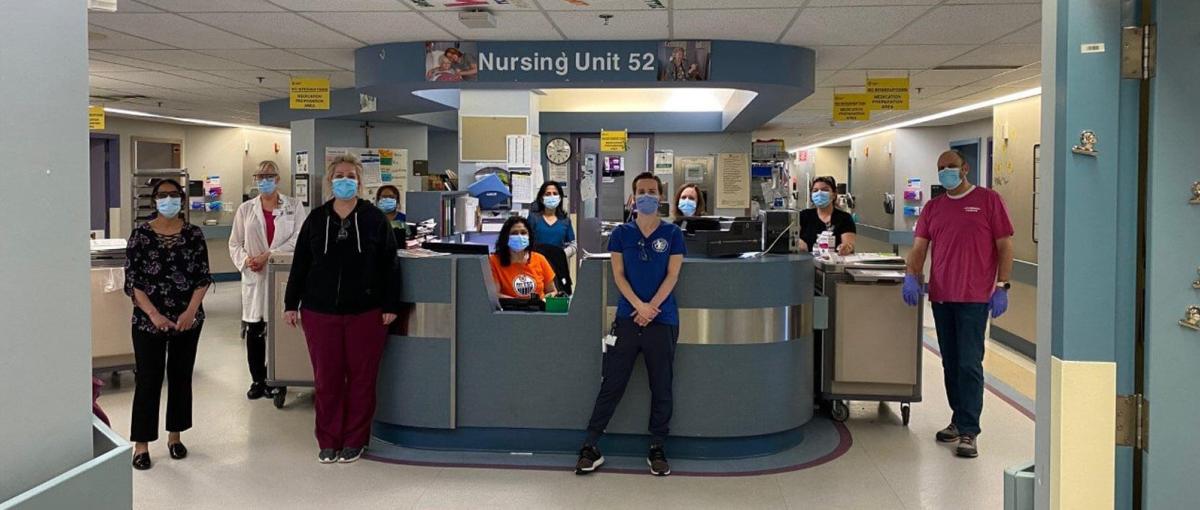 A healthcare team poses in front of nursing unit 52 at the Grey Nuns Community Hospital