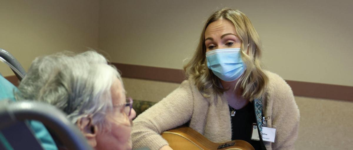 Music therapist Nadine Verboa plays on her guitar for a resident
