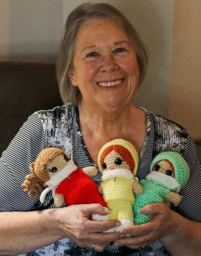 Carol Brown holding three crochet dolls