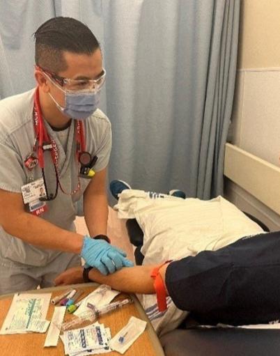 Jason takes a blood sample from a patient in the emergency department.