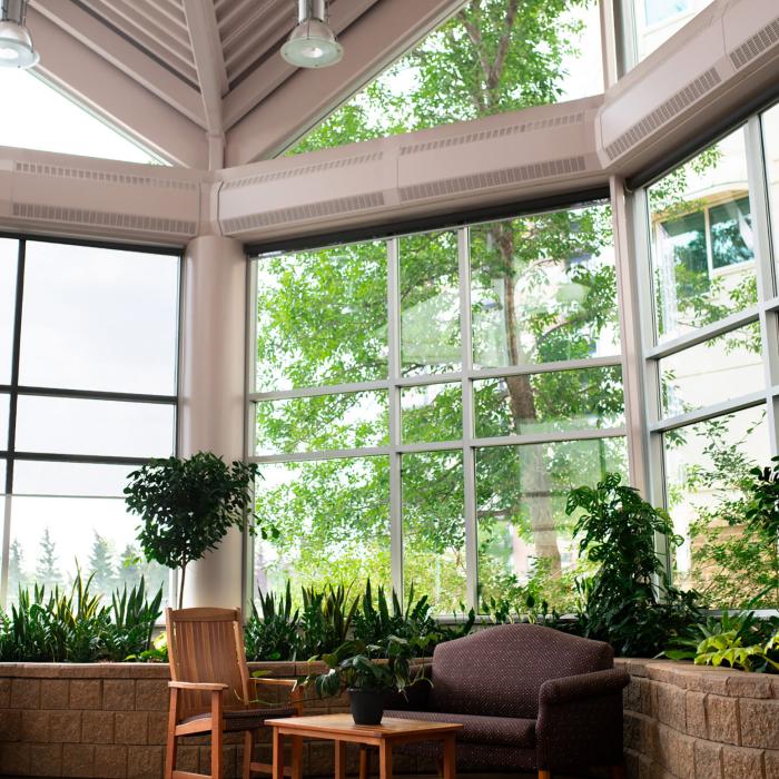 Glass solarium with seating and plants