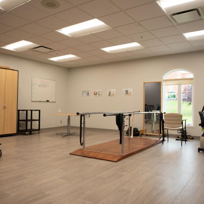 Physical therapy area with walkers and exercise equipment