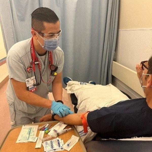 Jason takes a blood sample from a patient in the emergency department.