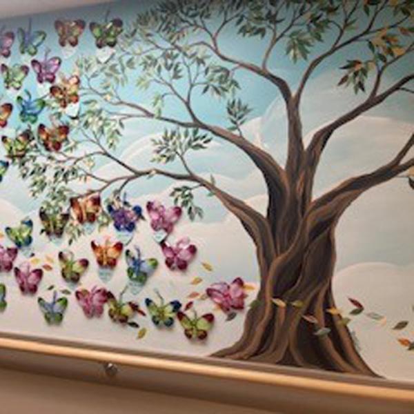 Painted mural of a tree and a kaleidoscope of butterflies