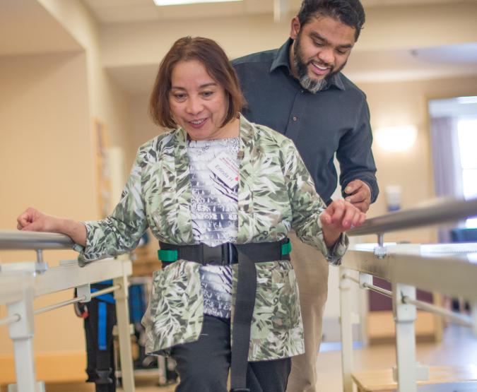 A physiotherapist helps a patient during rehab exercises.